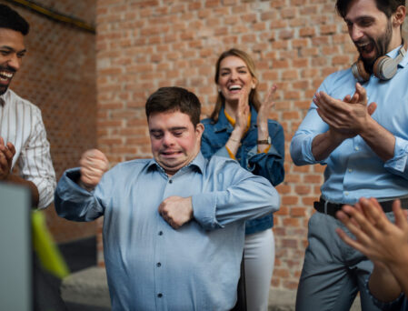 Cheerful young businesspeople having fun in a office, social inclusion and cooperation concept.